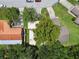 Aerial view of a well-maintained residential property with mature trees and a white roof at 519 Market W Sq, Lakeland, FL 33813