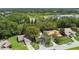 Aerial view of a house surrounded by lush greenery, with a glimpse of a pond in the distance at 519 Market W Sq, Lakeland, FL 33813