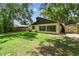 A spacious backyard featuring lush green grass and a storage shed, surrounded by mature trees and partial fencing at 519 Market W Sq, Lakeland, FL 33813