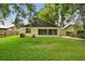 An expansive backyard with green grass, partial fencing, and a storage shed provides privacy and room for outdoor activities at 519 Market W Sq, Lakeland, FL 33813