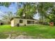 A serene backyard with healthy grass and a small shed, backed by established trees and privacy fencing at 519 Market W Sq, Lakeland, FL 33813
