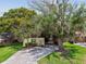 A charming home featuring a covered driveway with attractive landscaping and mature trees at 519 Market W Sq, Lakeland, FL 33813
