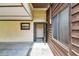 A covered entryway with a secure screen door, situated beside wood-paneled walls and windows at 519 Market W Sq, Lakeland, FL 33813