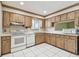 A charming kitchen with wooden cabinetry, white appliances, and tile flooring at 519 Market W Sq, Lakeland, FL 33813
