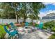 Paver patio with modern fire pit and colorful Adirondack chairs surrounded by mature landscaping and fence at 811 Patricia Pl, Lakeland, FL 33809