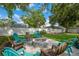 Beautiful paver patio with fire pit and colorful chairs with a white vinyl fence and blue skies at 811 Patricia Pl, Lakeland, FL 33809