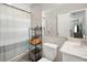 Functional bathroom with white fixtures, a mirrored wall, and convenient storage shelves at 811 Patricia Pl, Lakeland, FL 33809