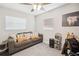 Neutral room with modern ceiling fan, gray couch, small desk, and natural light from two windows at 811 Patricia Pl, Lakeland, FL 33809