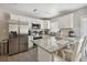 Modern kitchen featuring white cabinets, stainless steel appliances, and a granite countertop island at 811 Patricia Pl, Lakeland, FL 33809