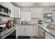 Bright kitchen features white cabinets, stainless steel appliances, and granite countertops at 811 Patricia Pl, Lakeland, FL 33809
