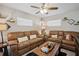 Cozy living room with leather sofas, ceiling fan, decorative pillows and a rustic coffee table at 811 Patricia Pl, Lakeland, FL 33809