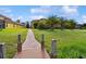 Well-maintained backyard with lush green grass and a brick paver path leading to a waterfront home at 1140 Terralago Way, Kissimmee, FL 34746
