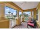 Relaxing outdoor balcony features white pillars and two chairs with red cushions at 1140 Terralago Way, Kissimmee, FL 34746