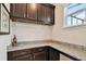 Elegant bar area featuring dark wood cabinets, granite countertops, and a wine glass rack at 1140 Terralago Way, Kissimmee, FL 34746