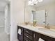 Bathroom featuring a double sink, dark cabinets, and a large mirror at 1140 Terralago Way, Kissimmee, FL 34746