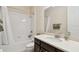 Bright bathroom featuring a tub with shower, dark cabinets, and a framed mirror at 1140 Terralago Way, Kissimmee, FL 34746