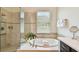 Elegant bathroom with a soaking tub, walk-in shower and neutral-toned tile at 1140 Terralago Way, Kissimmee, FL 34746