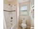 Bathroom featuring a white bathtub/shower combo, toilet and window with blinds at 1140 Terralago Way, Kissimmee, FL 34746