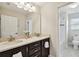 Elegant bathroom with double sinks, dark cabinets, and a view of the shower and toilet at 1140 Terralago Way, Kissimmee, FL 34746
