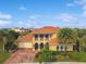 Stunning two-story home with a red tile roof, lush landscaping, and a paver driveway at 1140 Terralago Way, Kissimmee, FL 34746
