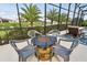 Outdoor screened-in patio with a fire pit and comfortable seating, perfect for entertaining guests at 1140 Terralago Way, Kissimmee, FL 34746