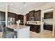Modern kitchen with dark cabinets, stainless steel appliances, and a granite island, ideal for cooking at 1140 Terralago Way, Kissimmee, FL 34746