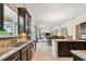 Spacious kitchen open to the living and dining areas features dark cabinets and granite countertops at 1140 Terralago Way, Kissimmee, FL 34746