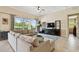Bright living room featuring large windows, comfortable seating, and a ceiling fan at 1140 Terralago Way, Kissimmee, FL 34746