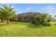 Screened-in patio with palm trees offers privacy and shade to enjoy the expansive backyard at 1140 Terralago Way, Kissimmee, FL 34746