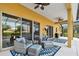 Covered patio with comfortable seating, ceiling fans, and large sliding glass doors at 1140 Terralago Way, Kissimmee, FL 34746
