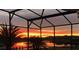 Stunning sunset view from a screened-in lanai overlooking the lake at 1140 Terralago Way, Kissimmee, FL 34746