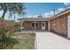 Brick home with a covered porch and lush landscape in the backyard at 1212 Blake Ave, Auburndale, FL 33823