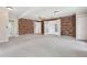 Large bedroom with brick accent wall and a view into the bathroom at 1212 Blake Ave, Auburndale, FL 33823