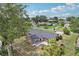 Aerial view of a home with patio, showcasing well-maintained lawn and nearby waterway at 1212 Blake Ave, Auburndale, FL 33823