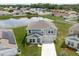 Exterior view of the two-story home showcasing the front yard, driveway, and partial view of a neighborhood pond at 1424 Axel Cir, Winter Haven, FL 33880