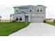Two-story home with gray and blue siding, white trim, and a two-car garage, set on a green lawn at 1424 Axel Cir, Winter Haven, FL 33880