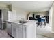 Open kitchen and living space with light-colored cabinets, stainless steel appliances, and a view of the stairs at 1424 Axel Cir, Winter Haven, FL 33880
