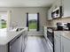 Modern kitchen featuring gray cabinets, quartz countertops, and stainless steel appliances, offering a bright atmosphere at 1424 Axel Cir, Winter Haven, FL 33880