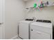 Bright laundry room features a washer, dryer, and shelving for convenient storage at 1424 Axel Cir, Winter Haven, FL 33880