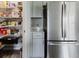 Walk-in pantry with wire shelving, stainless steel refrigerator, and ample storage space at 1424 Axel Cir, Winter Haven, FL 33880