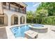 Backyard featuring a pool, raised spa, and second story balcony with iron railing at 952 Moss Ln, Winter Park, FL 32789