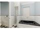 Bright bathroom with black tub, tiled walls and floor features a walk-in shower providing a spa-like retreat at 952 Moss Ln, Winter Park, FL 32789
