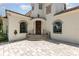 Elegant home entrance with a wooden door, wrought iron details, and brick paver driveway at 952 Moss Ln, Winter Park, FL 32789