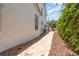 Side exterior of the property featuring a brick walkway, clean stucco and lush foliage at 952 Moss Ln, Winter Park, FL 32789