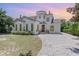 Charming two-story home featuring stucco siding, a tile roof, arched windows, and a brick driveway at 952 Moss Ln, Winter Park, FL 32789