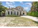 Charming two-story home featuring stucco siding, a tile roof, arched windows, and a brick driveway at 952 Moss Ln, Winter Park, FL 32789