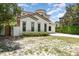 Side view of a charming two-story home featuring stucco siding, a tile roof, arched windows, and manicured landscaping at 952 Moss Ln, Winter Park, FL 32789
