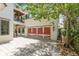 Garage exterior featuring wood doors, sconce lighting, and brick driveway at 952 Moss Ln, Winter Park, FL 32789