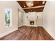 Bright living room with hardwood floors, large windows, a fireplace, and a wood-beamed ceiling at 952 Moss Ln, Winter Park, FL 32789