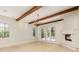 Bright living room featuring beautiful wood beam ceilings, fireplace, and access to the backyard at 952 Moss Ln, Winter Park, FL 32789